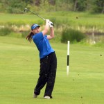 Barlow golfer Ella Wishart in a blue top and black bottoms swings a golf club on a sunny day out on the green during the Regional Golf Tournament