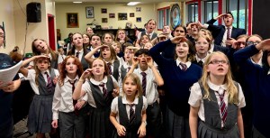 The Eastside Theater Company kid actors of Matilda the Musical stand in a group, wearing their gray school costumes