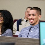 Xavier Juarez sits to the right of another youth, both smiling