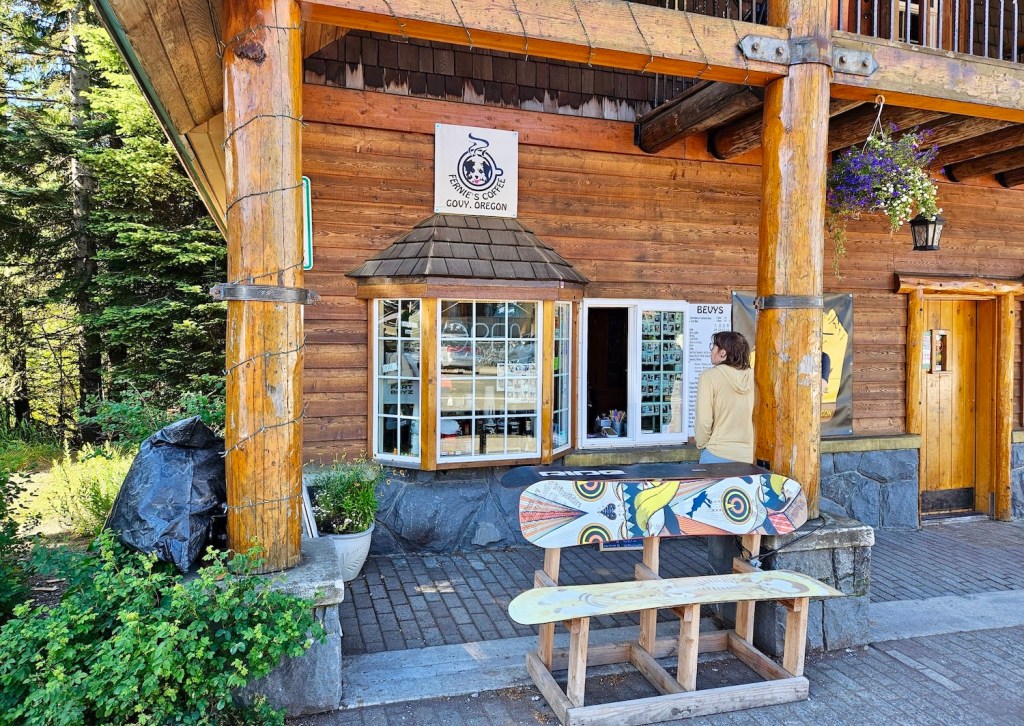 The new coffee window for Fernie's Coffee in Government Camp. It is in the wall at Vallian's Sports with a bench and plants in front.